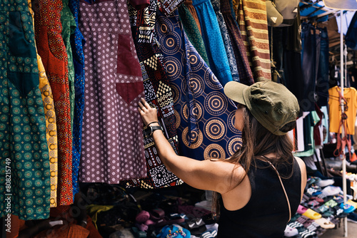Woman browsing colorful fabrics at a street market photo