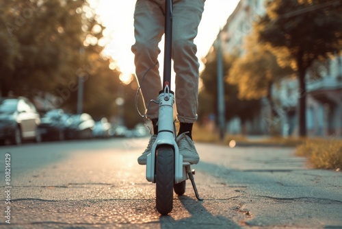 Close-up of a rider on an e-scooter on city streets during the warm evening light