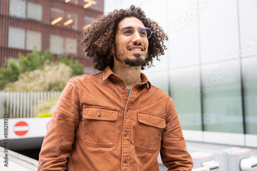 Man in urban setting looking away thoughtfully photo