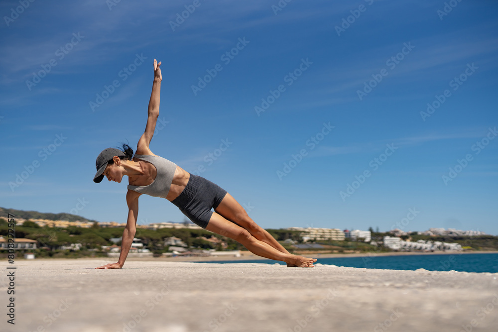 Sultry Brunette Athlete in Sportswear and Baseball Cap Training by the Sea Sultry Brunette Athlete in Sportswear and Baseball Cap Training by the Sea