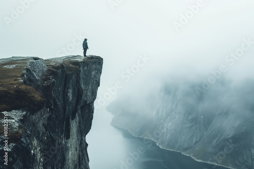 person standing at the edge of a cliff overlooking a breathtaking view photo