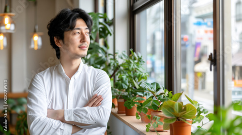 Japanese businessman looking out window in modern office, pensive thoughtful entrepreneur startup, visualizing success Free Download Japanese businessman looking out window in modern office, pensive thoughtful entrepreneur startup, visualizing success - GFXLoad