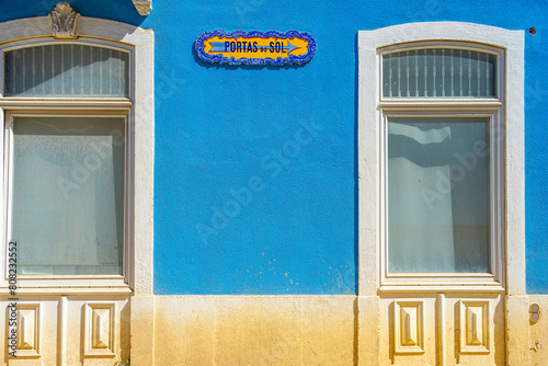 Front facade of a residential building painted blue with tiles reading "Portas do Sol", Santarém-Portugal.