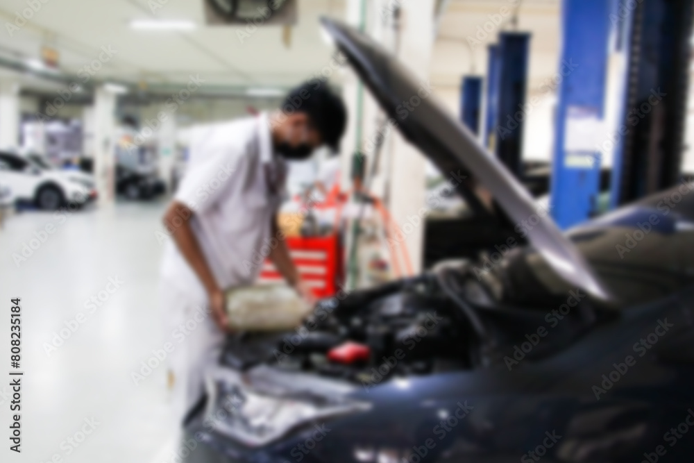 Blurry car repair station and repairman working in the garage. Car maintenance or checking of car repair concept. Blurry car repair station and repairman working in the garage. Car maintenance or checking of car repair concept.