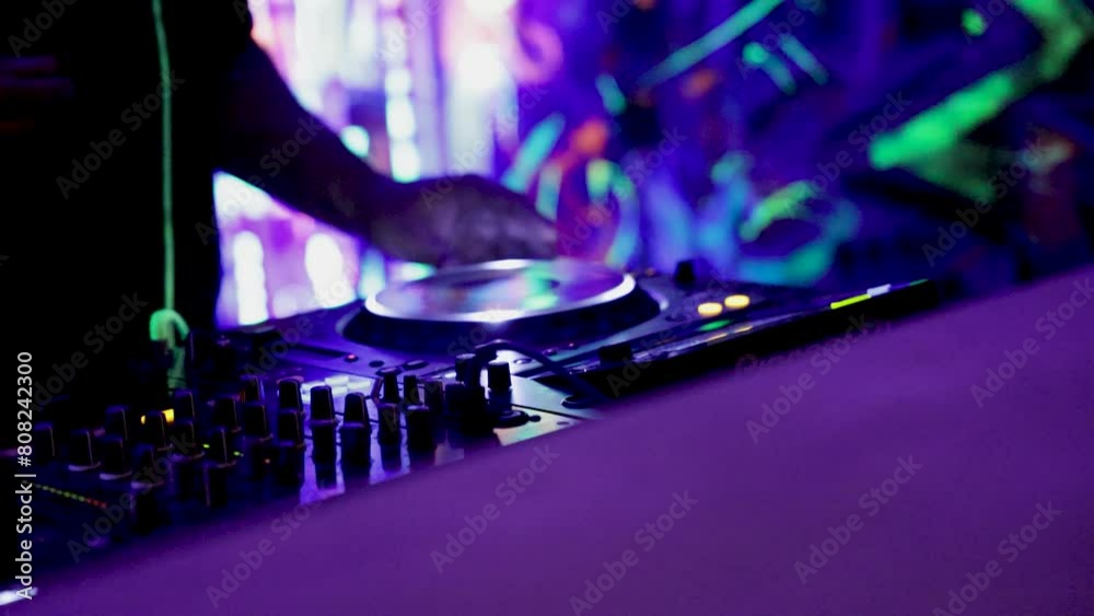 the DJ works at the remote control. neon lights all around