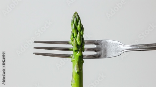 asparagus on a fork, Steamed asparagus spear on a fork against a grey background. Minimalistic food concept with copy space. Design for healthy eating blog and culinary poster.