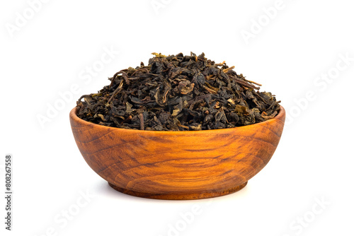 Dried tea leaves in wooden teak bowl isolated on white background.