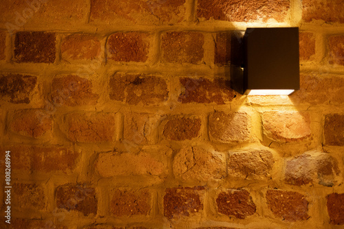 Parede de tijolos com luminária no fundolamp with warm light on rustic brick wall photo