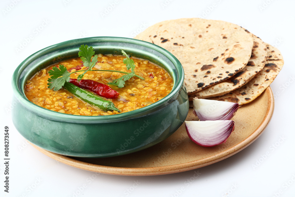 Indian popular food Dal Tadka Curry served with roti flatbread close-up on the table. Vertical top view from above Indian popular food Dal Tadka Curry served with roti flatbread close-up on the table. Vertical top view from above