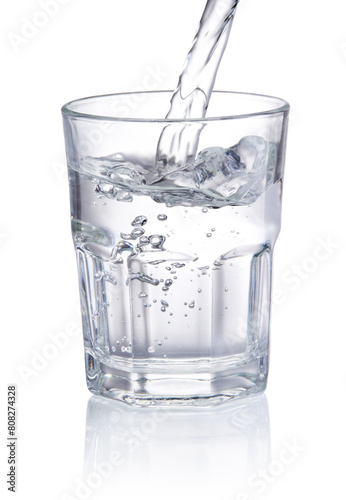 Pouring drinking water into glass isolated on white background