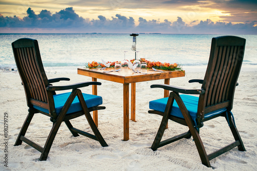 romantic dinner table setting on sunset beach