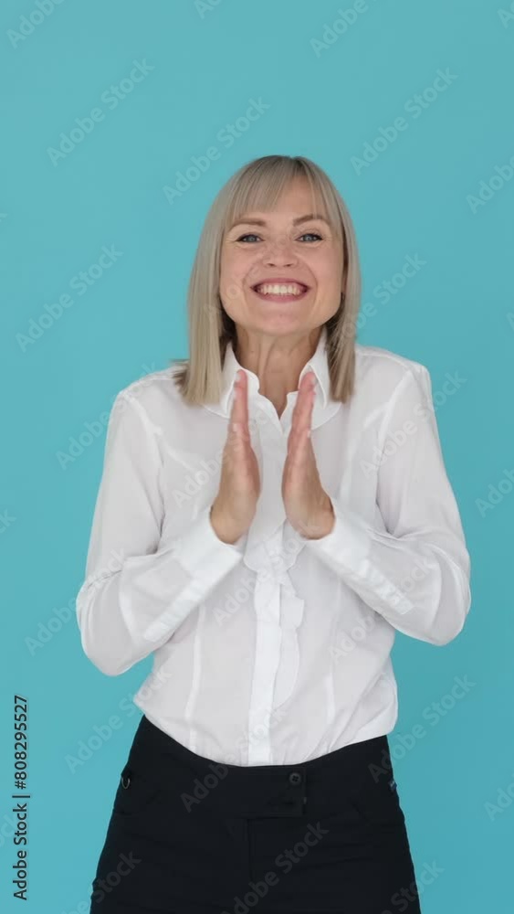 Happy Caucasian female employee clapping in congratulation, agreement, appreciation on blue background. Approve, respect. Vertical video. Happy Caucasian female employee clapping in congratulation, agreement, appreciation on blue background. Approve, respect. Vertical video.