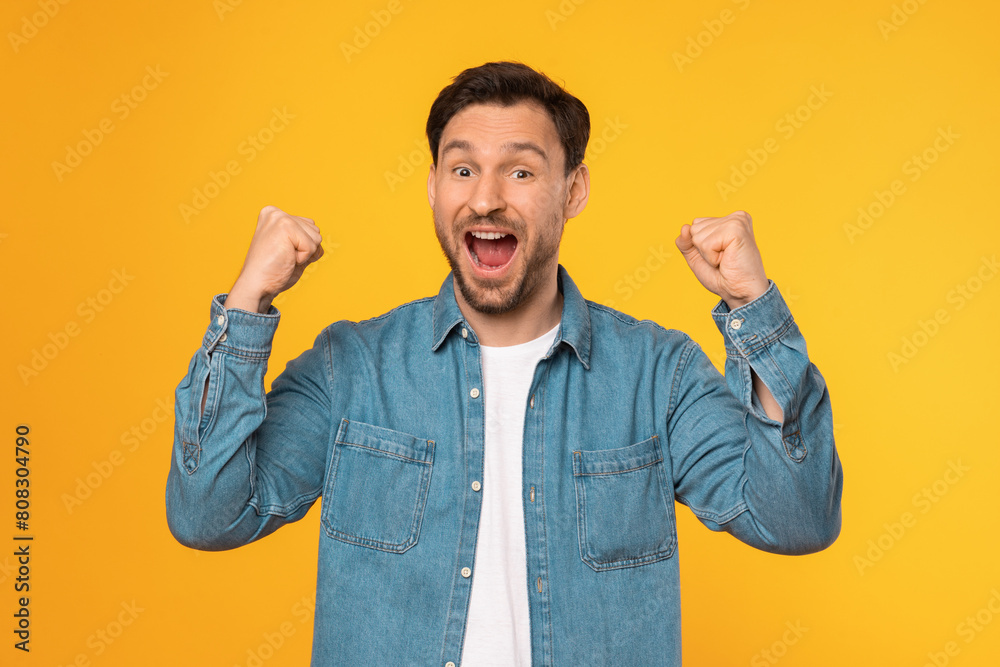 A man wearing a blue shirt is standing with his fists raised in a defensive or confrontational position. He appears ready for physical confrontation or to defend himself against a possible threat. A man wearing a blue shirt is standing with his fists raised in a defensive or confrontational position. He appears ready for physical confrontation or to defend himself against a possible threat.