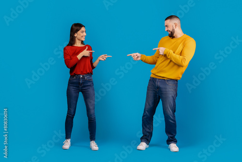 Bilde på lerret A man and a woman standing facing each other, both pointing accusingly at each other with serious expressions