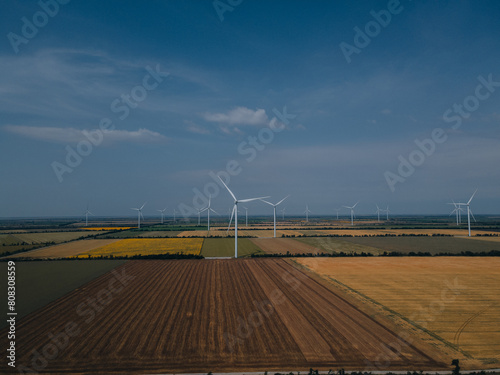 Wind power plant on a green field. Clean energy future. Photography from above. Energy in Ukraine.