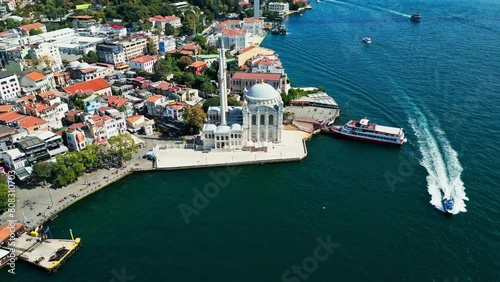 Aerial drone video of the Ortaköy Mosque or Büyük Mecidiye Camii in Beşiktaş, Istanbul, Turkey during a sunny day on the side of Bosphorus	 photo