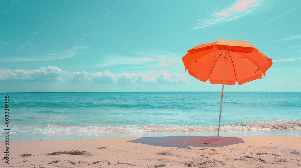 Relaxing beach scene with orange umbrella and blue ocean