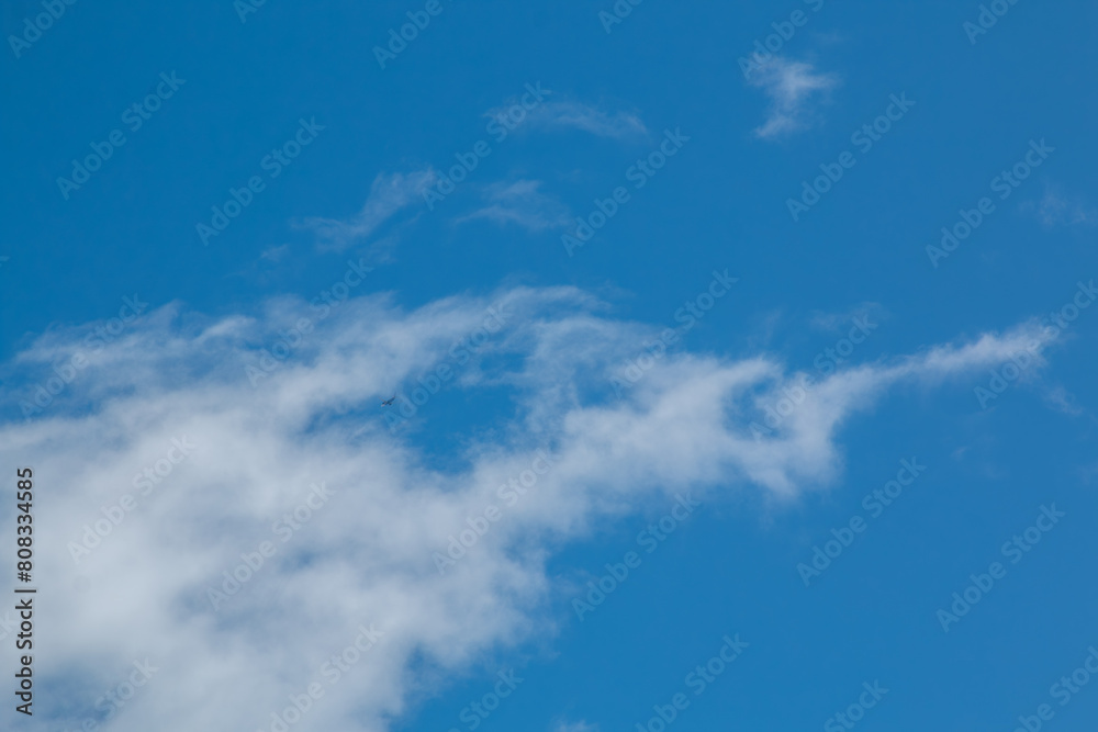 blue sky with clouds and a plane