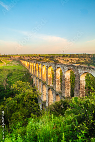 Aqueduct between mountains at sunrise with cloudy sky in arcos del sitio in tepotzotlan state of mexico
