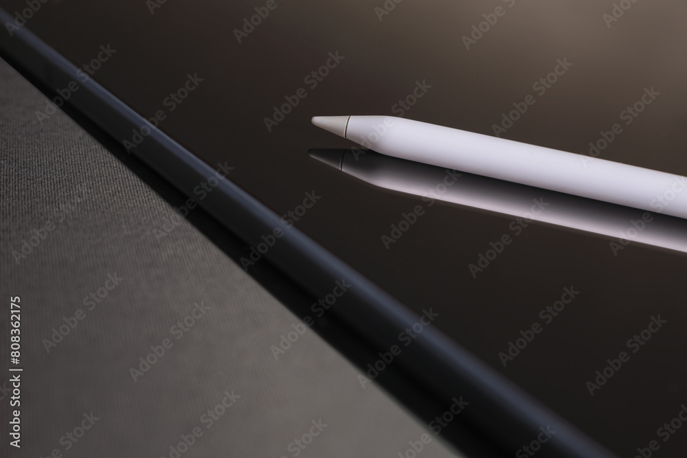 Close-up of digital tablet and pencil on black background Close-up of digital tablet and pencil on black background