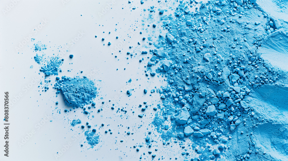 Close-up of scattered blue powder on light background Close-up of scattered blue powder on light background