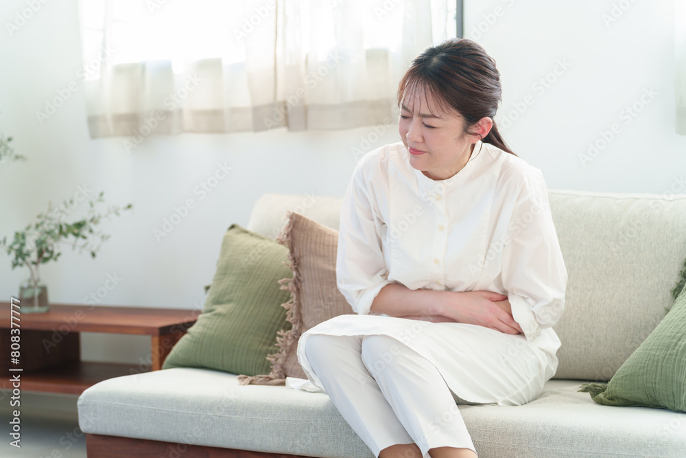 お腹を押さえる女性 体調不良 腹痛 お腹を押さえる女性 体調不良 腹痛