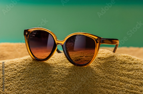 Ambar summer plastic sunglasses modern and minimal style on sandy beach and squamarine background photo