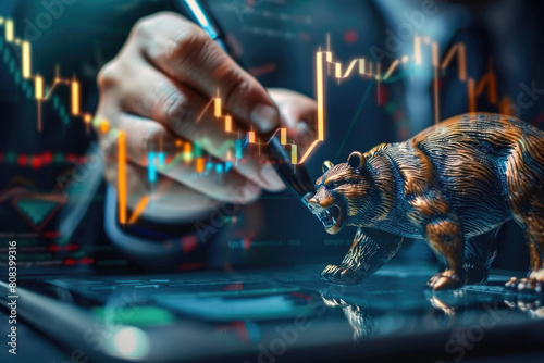 A businessman is drawing an down trending graph on his tablet screen about the stock market, and he holds a pen in one hand with bear near him against a financial background