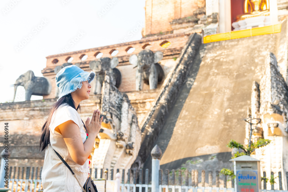 Happy Asian woman traveler enjoy and fun outdoor lifestyle travel in Thailand on summer holiday vacation. Attractive girl tourist travel old traditional Buddhist temple in Chiang Mai.
