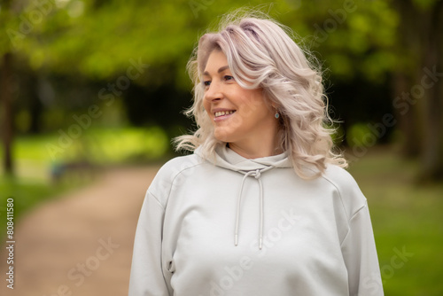 Woman with silver hair smiling in the park © InfiniteStudio