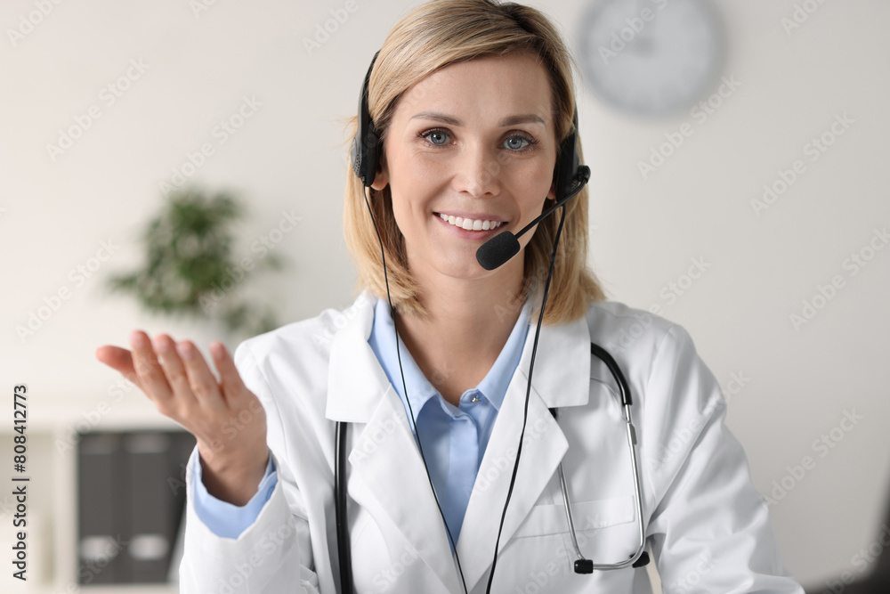Smiling doctor wearing headphones having online in office Smiling doctor wearing headphones having online in office