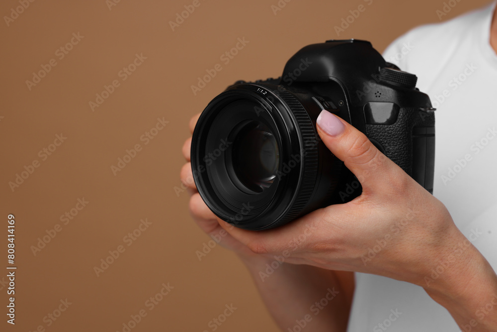 Photographer with camera on brown background, closeup. Space for text Photographer with camera on brown background, closeup. Space for text