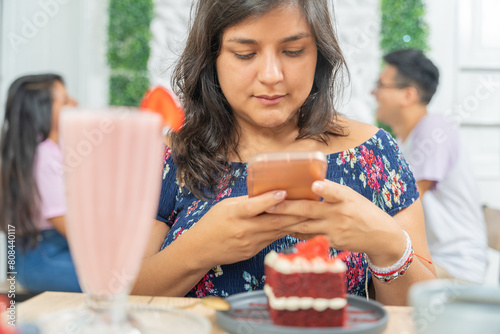 Woman eating a dessert and a milkshake in a cafeteria