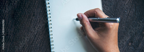 Banner Woman hands writing empty notebook planing meeting agenda wooden table. Panorama Close up women hands using pen drawing on paper planning note diary. Female hand holding pen with copy space