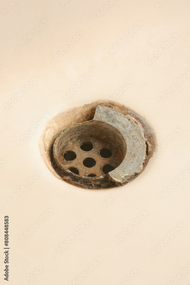 old broken and dirty bathroom sink drain mesh hole close-up, rusty limescale bath or tub drainage, cleaning repairing bathroom equipment concept, isolated background with copy space