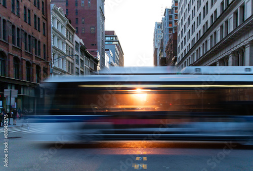 Sunlight shining through a city bus as it's driving down the street on 5th Avenue in New York City with motion blur effect photo