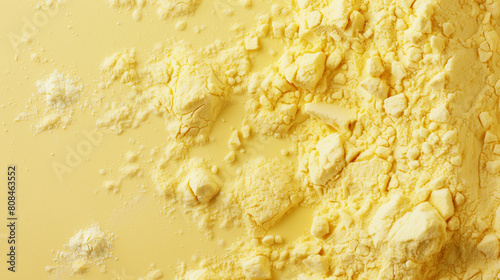 Close-up of textured yellow powder on pastel background