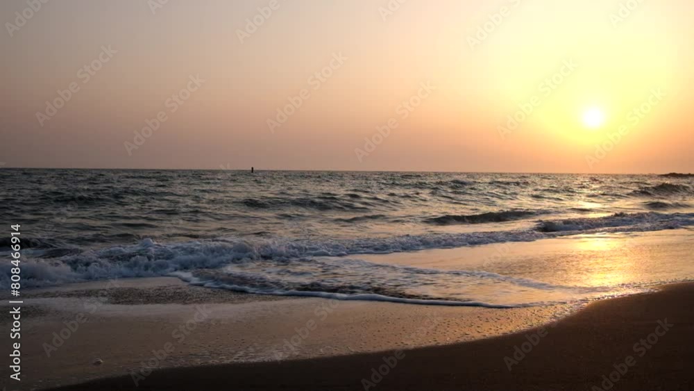 晴れた空と沈む夕日と白い波が打ち寄せる波打ち際 晴れた空と沈む夕日と白い波が打ち寄せる波打ち際