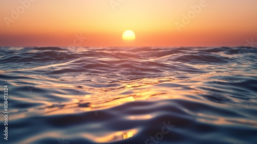 Tranquil sunset over calm ocean waves in warm tones with clear sky.