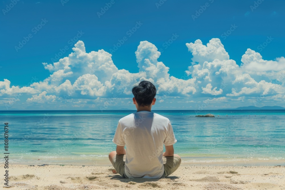 Fototapeta premium 海を見ている日本人男性の後ろ姿（ビーチ・青空・旅行・休暇）