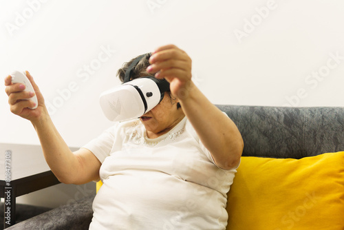 A woman is sitting on a couch and playing a video game
