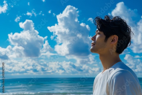 海を見ている日本人男性の横顔（ビーチ・青空・旅行・休暇）