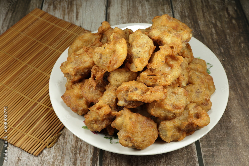 Pile of deep fried pork ribs dressing with flour serving on the plate. Famous appetizer menu in Chinese restaurant. Pile of deep fried pork ribs dressing with flour serving on the plate. Famous appetizer menu in Chinese restaurant.