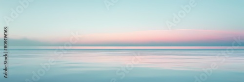 minimalist dawn over a serene blue sky and water  with a pink cloud adding a pop of color
