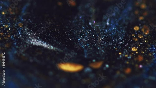 Sparkling liquid. Glitter paint wave. Defocused blue black gold color shimmering wet ink flow motion on dark abstract art background. photo