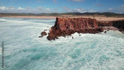 Push in panoramic view of peninsula with waves crashing and beach shoreline in Bordeira, the algarve region of Portugal by 4k drone
