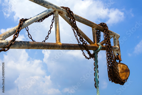Rusty chain on the jetty with blue sky at port