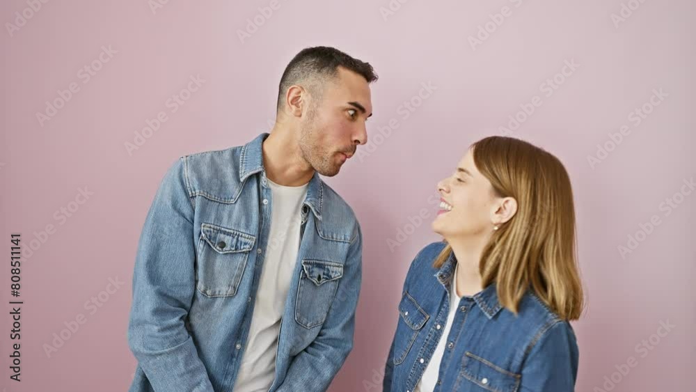 Hilarious love! beautiful couple wearing denim shirts, standing over a pink background, making goofy fish faces. crazy, comical fun! Hilarious love! beautiful couple wearing denim shirts, standing over a pink background, making goofy fish faces. crazy, comical fun!