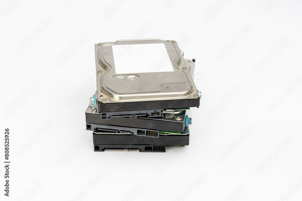 A pile of 3.5 inch computer internal hard disk drives isolated on white background with copy space. A pile of 3.5 inch computer internal hard disk drives isolated on white background with copy space.