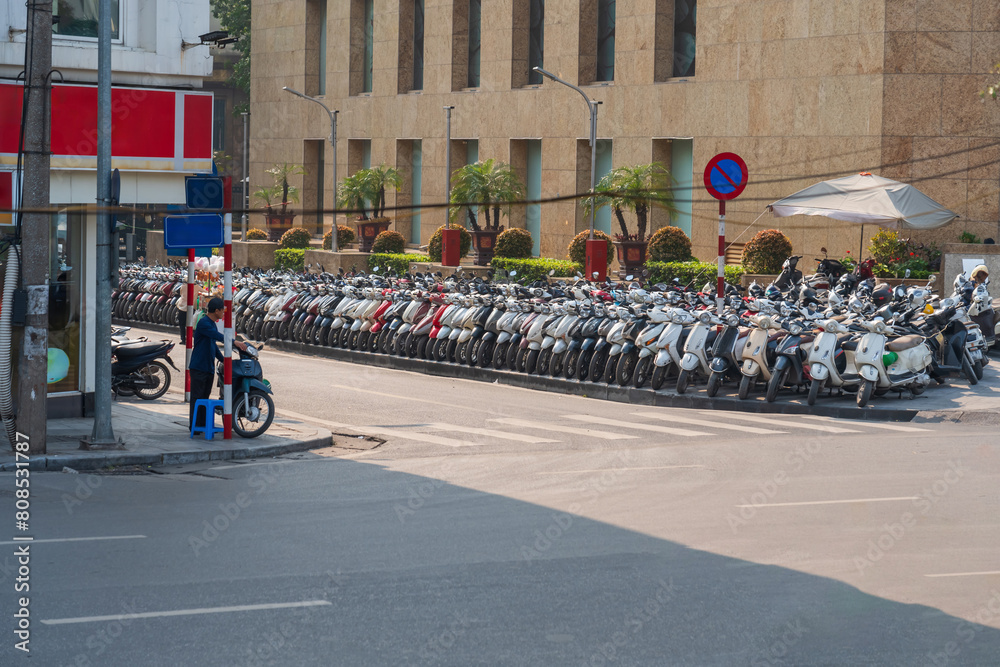 Fototapeta premium Street with many motorbike, motorcycle scooters parked in row in Hanoi, Vietnam